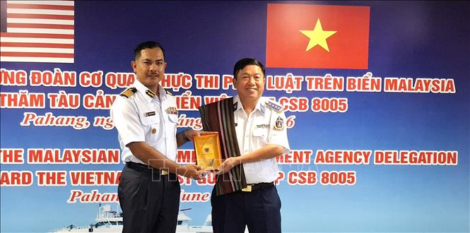 Đại tá Trần Nguyên Lai, Phó tư lệnh, Tham mưu trưởng Bộ tư lệnh Vùng Cảnh sát biển 4, tặng quà lưu niệm cho ông Mohd Marmizi bin Md Nor, Phó Giám đốc Cơ quan thực thi hàng hải Malaysia (MMEA) bang Pahang. Ảnh: Bùi Hoàn - PV TTXVN tại Malaysia