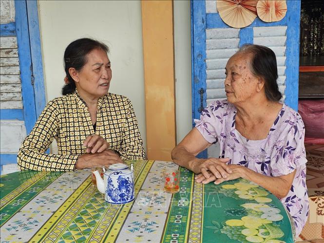 Bà Bùi Thị Triếu (trái), Trưởng ấp Mai Vàng, xã Tân Tây, luôn gần dân trong mọi công tác. Ảnh: Đức Hạnh - TTXVN