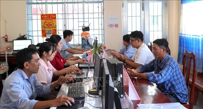Công chức Trung tâm phục vụ hành chính công xã Vân Khánh (An Giang) hướng dẫn người dân giải quyết thủ tục hành chính. Ảnh: Văn Sĩ - TTXVN 