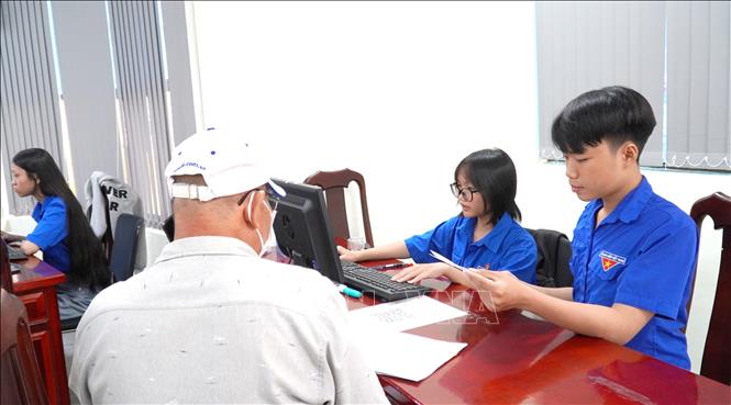 Đoàn viên thanh niên phường Rạch Giá (An Giang) hướng dẫn người dân làm các hồ sơ, thủ tục. Ảnh: Văn Sĩ - TTXVN 