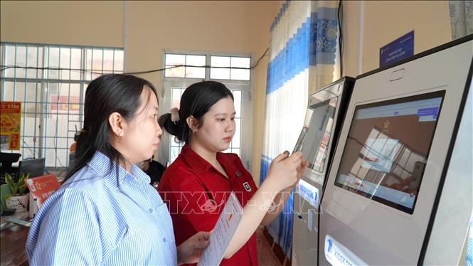 Công chức Trung tâm phục vụ hành chính công xã Vân Khánh (An Giang) hướng dẫn người dân làm hồ sơ bằng hệ thống dịch vụ công trực tuyến. Ảnh: Văn Sĩ - TTXVN 