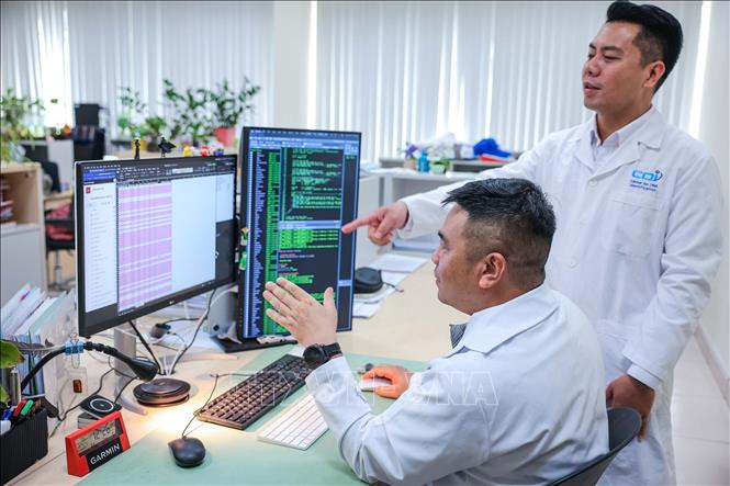Tiến sĩ Trần Trung Thành - Giám đốc Trung tâm Giám định ADN (Viện Công nghệ sinh học) trao đổi kết quả với kỹ thuật viên từ dữ liệu từ hệ thống giải trình tự gen thế hệ mới (NGS) được hiển thị trên hệ thống máy chủ và máy phân tích. Ảnh: Hoàng Hiếu - TTXVN