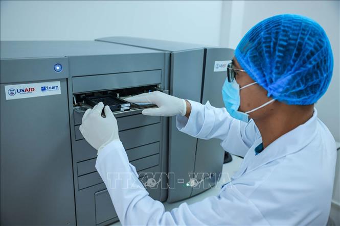 Kỹ thuật viên thực hiện xét nghiệm ADN thân nhân liệt sĩ trên máy microarray GeneTitan thể mô có thể phân tích hàng nghìn mẫu mô cùng lúc để tìm đột biến di truyền hoặc mức độ hoạt động của gen. Ảnh: Hoàng Hiếu - TTXVN