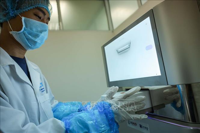 Trung tâm sử dụng Máy giải trình tự gen thế hệ mới(NGS - Next-Generation Sequencing) illumina nextseq 1000 với công nghệ phân tích DNA/RNA quy mô lớn. Thiết bị này đọc hàng triệu đoạn gen cùng lúc, giúp tăng tốc độ và giảm chi phí so với phương pháp cũ. Phần mềm máy tính sau đó sẽ ghép các mảnh này lại thành một bức tranh gen hoàn chỉnh. Ảnh: Hoàng Hiếu - TTXVN