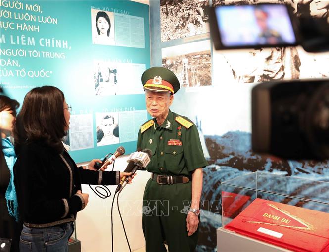 Anh hùng LLVT nhân dân La Văn Cầu trả lời phỏng vấn tại triển lãm “Thanh niên Quân đội - Vững bước dưới cờ Đảng”  ở Bảo tàng Lịch sử Quân sự Việt Nam, tháng 3/2021. Ảnh: Thanh Tùng - TTXVN