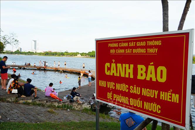 Có biển cảnh báo khu vực nước sâu nguy hiểm ở bờ Bắc sông Hương, thành phố Huế nhưng nhiều người vẫn tắm. Ảnh: Nguyên Lý - TTXVN