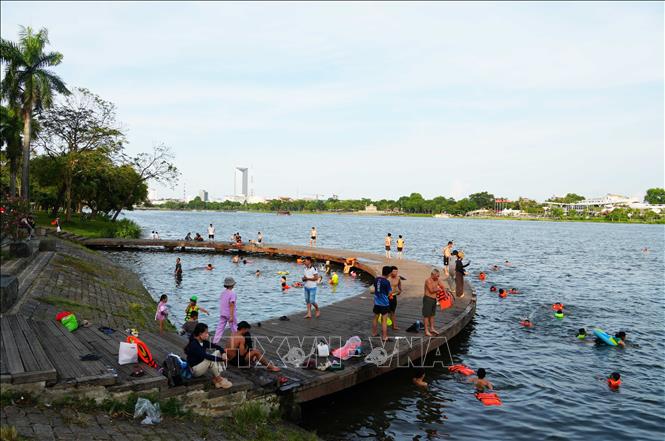 Nhiều người đến cầu bán nguyệt ở bờ Bắc sông Hương, thành phố Huế để tắm giải nhiệt nắng nóng gay gắt. Ảnh: Nguyên Lý - TTXVN