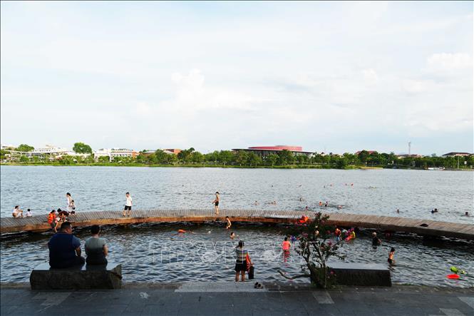 Nhiều người đến cầu bán nguyệt ở bờ Bắc sông Hương, thành phố Huế để tắm giải nhiệt nắng nóng gay gắt. Ảnh: Nguyên Lý - TTXVN