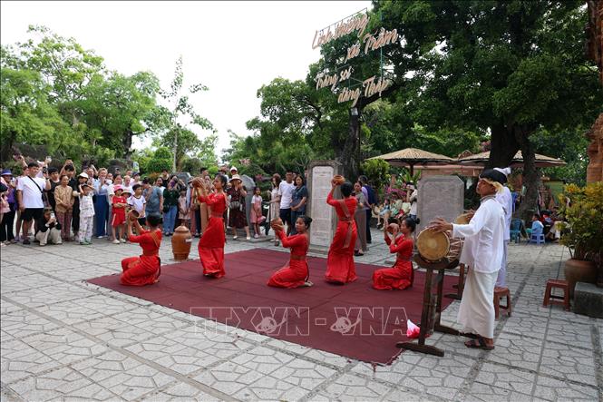 Du khách thế hệ trẻ hào hứng tìm hiểu lịch sử, nguồn gốc các tầng tháp cổ. Ảnh: Đặng Tuấn - TTXVN