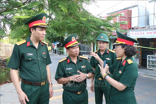 Đại tá Đinh Xuân Hướng, Phó Chủ nhiệm Chính trị Quân khu 4 (bìa trái) làm việc với lãnh đạo Bộ chỉ huy Quân sự thành phố Huế về việc sử dụng máy radar xuyên đất rà soát khu vực nghi có mộ liệt sĩ. Ảnh: Mai Trang - TTXVN