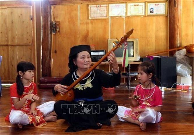 Bà Hà Thị Mỵ, người dân tộc Tày đang dạy hát then cho con cháu. Ảnh Quang Đán - TTXVN