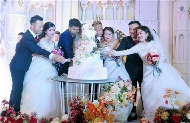 Các cặp đôi thực hiện nghi lễ cắt bánh tại Lễ cưới tập thể cho 19 cặp đôi là công nhân, người lao động có hoàn cảnh khó khăn do Liên đoàn Lao động tỉnh Thái Nguyên tổ chức. Ảnh: Thu Hằng - TTXVN