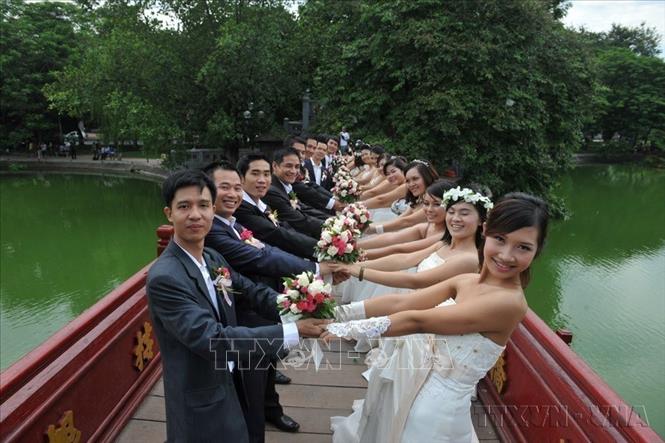 Chụp ảnh cưới tập thể của 50 cặp vợ chồng ở 3 miền Bắc - Trung - Nam tại Hồ Hoàn Kiếm, Hà Nội. Ảnh: TTXVN
