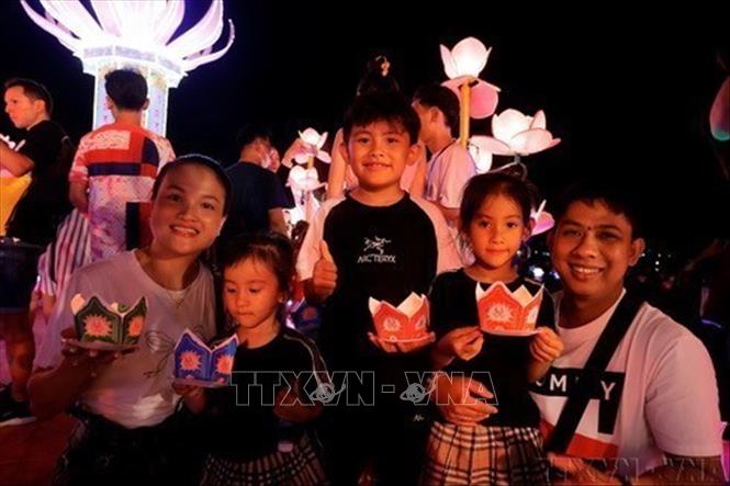 Cả gia đình cùng tham gia thả hoa đăng tại Tuần lễ Festival nghệ thuật Quốc tế Huế 2024. Ảnh: Minh Quyết - TTXVN