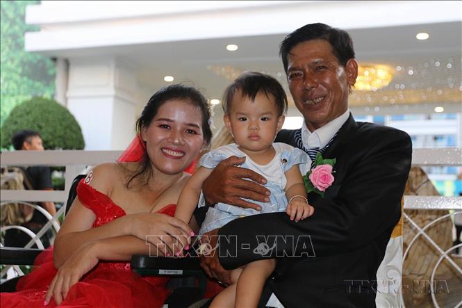 Niềm vui của một gia đình người khuyết tật tại lễ cưới tập thể cho 41 cặp đôi khuyết tật có hoàn cảnh đặc biệt khó khăn với chủ đề “Kết nối tin yêu - Vẹn tròn hạnh phúc” ở thành phố Hồ Chí Minh. Ảnh: Thanh Vũ - TTXVN