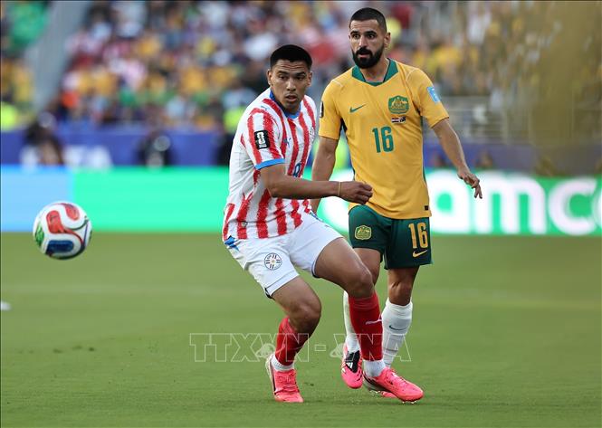 Pha tranh bóng giữa tiền vệ Paraguay Diego Gomez (trái) và hậu vệ Australia Aziz Behich. Ảnh: THX/TTXVN