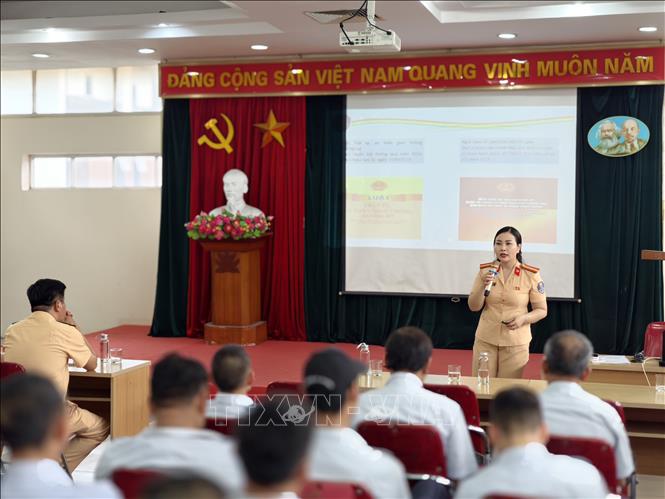 Cán bộ Đội Tuyên truyền, phòng Cảnh sát giao thông Hà Nội phổ biến những quy định mới về trật tự, an toàn giao thông; hướng dẫn kỹ năng nhận diện, phòng tránh nguy cơ mất an toàn trong quá trình vận hành xe buýt. Ảnh: Hùng Mạnh - TTXVN