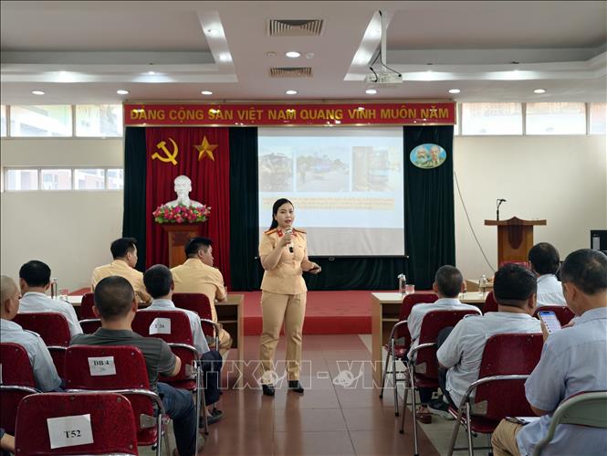Cán bộ Đội Tuyên truyền, phòng Cảnh sát giao thông Hà Nội phổ biến những quy định mới về trật tự, an toàn giao thông; hướng dẫn kỹ năng nhận diện, phòng tránh nguy cơ mất an toàn trong quá trình vận hành xe buýt. Ảnh: Hùng Mạnh - TTXVN