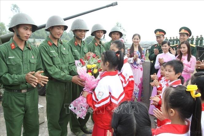 Các cháu học sinh tặng hoa chiến sỹ  Tiểu đoàn pháo 37 ly, Lữ đoàn pháo binh 210 (Quân khu 1) sau giờ huấn luyện (2012). Ảnh: Trọng Đức - TTXVN