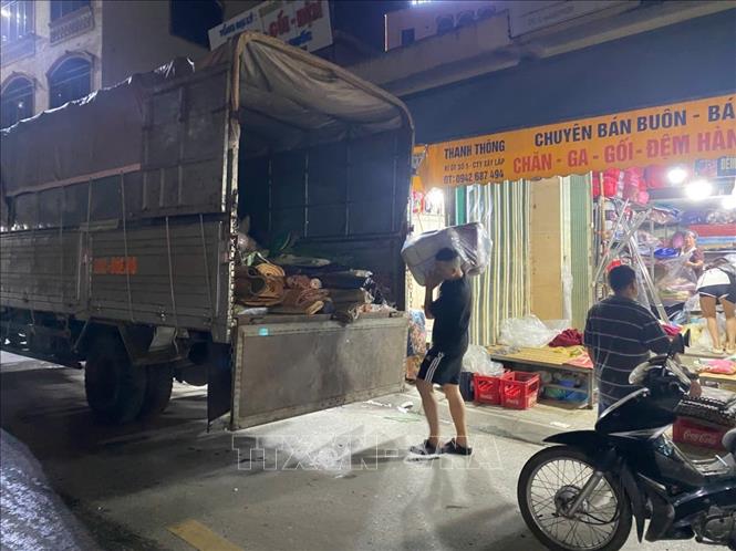 22 giờ, người dân khu vực Chợ Xanh, phường Thục Phán vẫn sơ tán hàng hóa đề phòng ngập lụt. Ảnh: Quốc Đạt - TTXVN