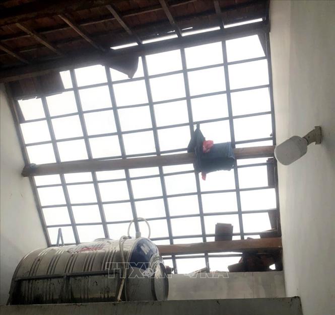 Mái ngói nhà dân bị hất tung cả mảng lớn. Ảnh: TTXVN phát