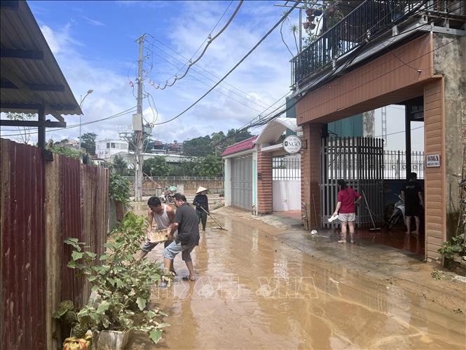 Người dân phố Cũ (phường Thục Phán) khẩn trương thu dọn vệ sinh, sớm ổn định lại cuộc sống. Ảnh: Chu Hiệu-TTXVN.