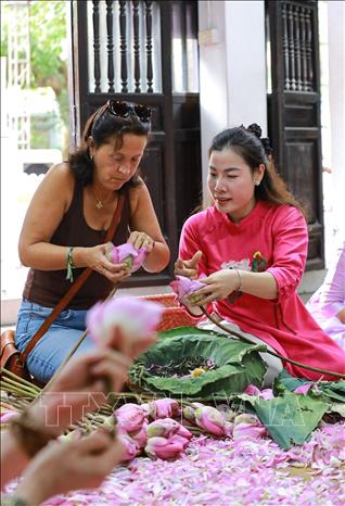 Du khách trải nghiệm nghề ướp trà sen Quảng An. Ảnh: Khánh Hoà - TTXVN