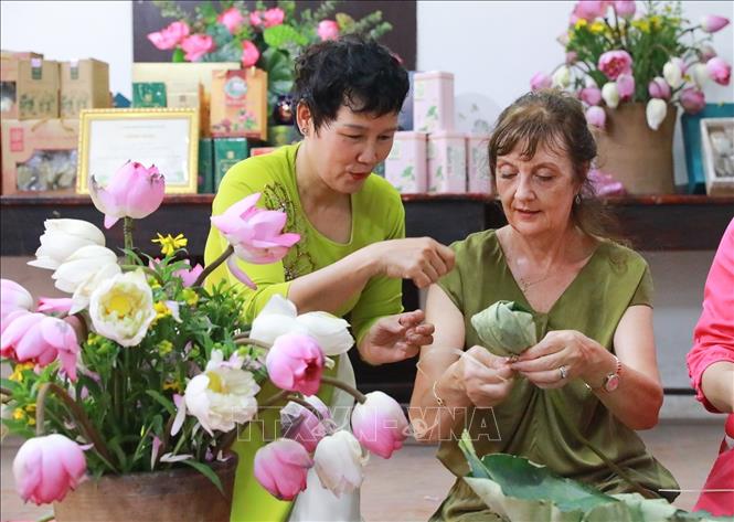 Du khách trải nghiệm nghề ướp trà sen Quảng An. Ảnh: Khánh Hoà - TTXVN
