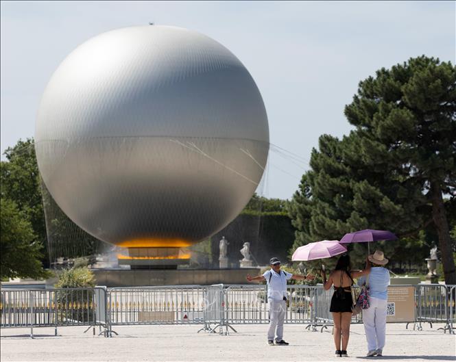 Du khách che ô chống nắng tại viện bảo tàng Louvre ở Paris, Pháp ngày 25/6/2026. Ảnh: THX/TTXVN