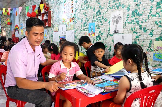 Thầy Nguyễn Khánh hướng dẫn các em học sinh ở lớp học hè. Ảnh: Lê Thúy Hằng – TTXVN
