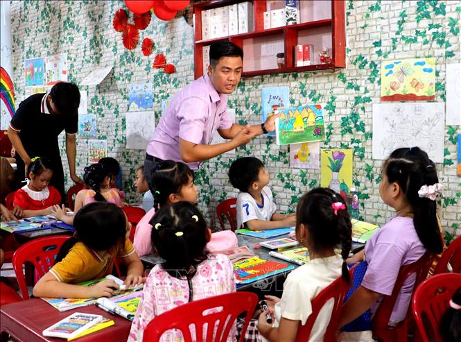 Thầy Nguyễn Khánh hướng dẫn các em học sinh ở lớp học hè. Ảnh: Lê Thúy Hằng – TTXVN

