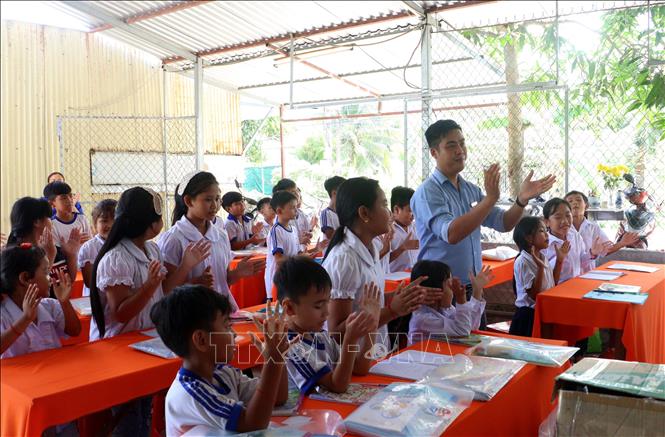 Thầy Nguyễn Khánh đến thăm và tổ chức hoạt động trải  nghiệm tại lớp học hè dành cho các em học sinh vùng đồng bào Khmer. Ảnh: Lê Thúy Hằng – TTXVN
