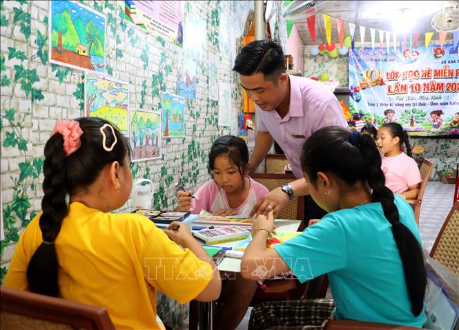 Thầy Nguyễn Khánh hướng dẫn các em học sinh ở lớp học hè. Ảnh: Lê Thúy Hằng – TTXVN
