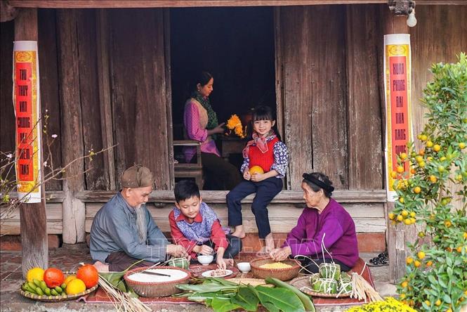  Các thành viên trong gia đình cùng nhau gói bánh chưng - một loại bánh truyền thống không thể thiếu trong dịp Tết đến Xuân về. Ảnh: Khánh Hoà - TTXVN
