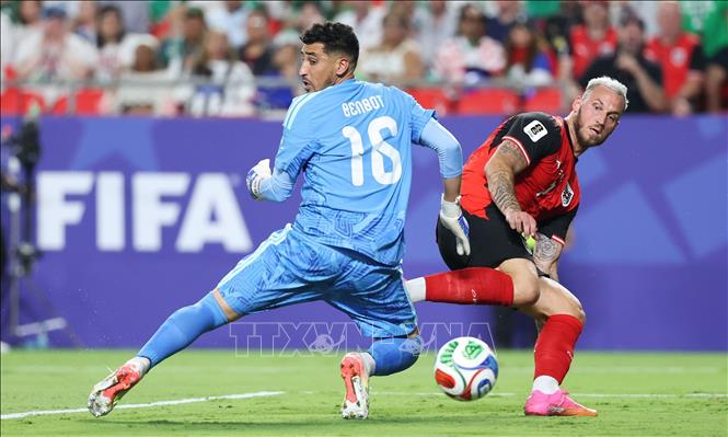 Pha tranh bóng giữa thủ môn Algeria Oussama Benbot (trái) và tiền đạo Áo Marko Arnautovic. Ảnh: THX/TTXVN phát