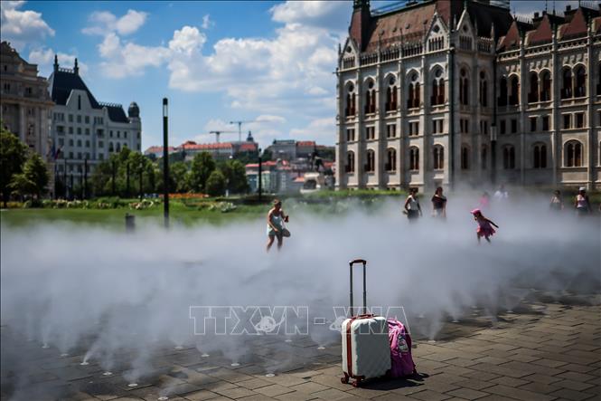 Người dân tránh nóng bên hệ thống phun sương ở Budapest, Hungary, ngày 24/6/2026. Ảnh: THX/TTXVN phát