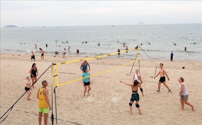 Du khách nước ngoài thích thú với môn bóng chuyền trên bãi biển Nha Trang (Khánh Hòa). Ảnh: Xuân Triệu - TTXVN 