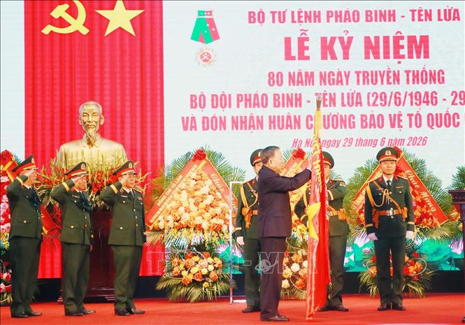 Tổng Bí thư, Chủ tịch nước Tô Lâm gắn Huân chương Bảo vệ Tổ quốc hạng Nhất lên Quân kỳ Quyết thắng của Bộ đội Pháo binh - Tên lửa. Ảnh: Trọng Đức - TTXVN