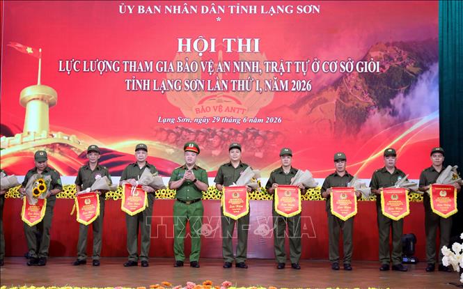 Thượng tá Nguyễn Hữu Đức, Phó Giám đốc Công an tỉnh Lạng Sơn trao cờ lưu niệm cho các đội thi. Ảnh: Văn Đạt - TTXVN