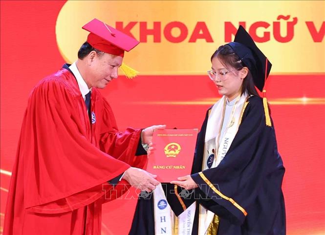 Sinh viên xuất sắc lớp CLC K72, Khoa Ngữ văn nhận bằng tốt nghiệp trong buổi lễ. Ảnh: Thanh Tùng - TTXVN