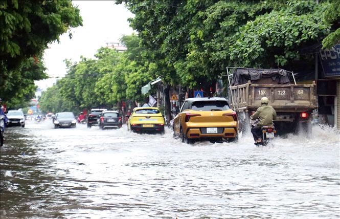 Tuyến đường Trần Nhân Tông ngập diện rộng sau cơn mưa. Ảnh: Hoàng Ngọc – TTXVN 