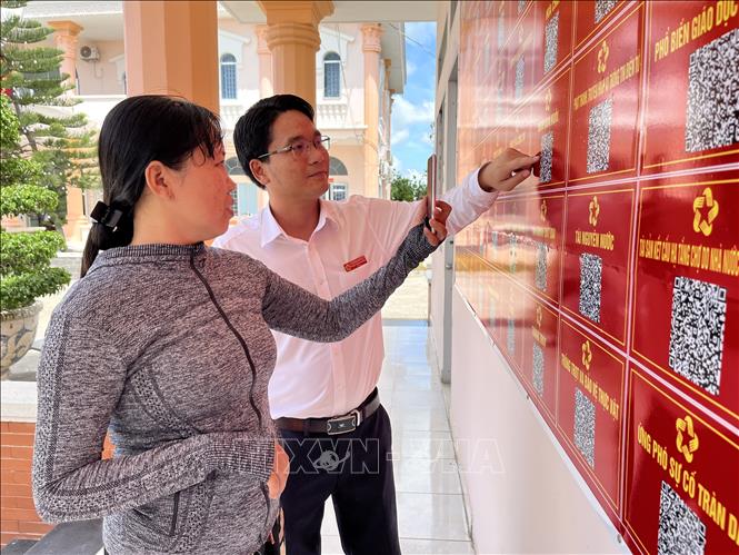 Giám đốc Trung tâm Phục vụ hành chính công xã Bình Hiệp - Phạm Anh Phương hướng dẫn người dân tra cứu thông tin trực tuyến. Ảnh: Đức Hạnh - TTXVN 