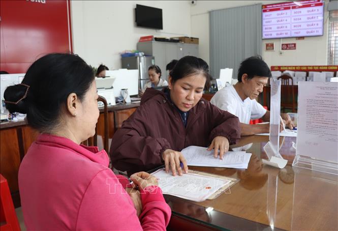 Người dân làm hồ sơ thủ tục hành chính tại Trung tâm Phục vụ hành chính công phường Long An. Ảnh: Đức Hạnh - TTXVN 