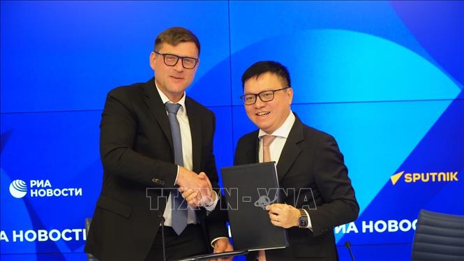Tổng biên tập báo Nhân Dân Lê Quốc Minh ký thoả thuận với Tập đoàn Truyền thông Rossiya Segodnya. Ảnh: Tâm Hằng, phóng viên TTXVN tại LB Nga