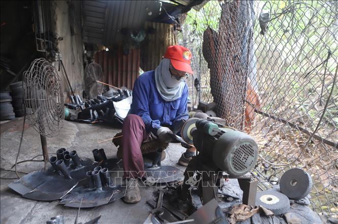 Công nhân Hợp tác xã Rèn Thanh niên, xã Vĩnh Phú (Phú Thọ) mài, hoàn thiện sản phẩm trước khi xuất xưởng. Ảnh: Nguyễn Thảo - TTXVN