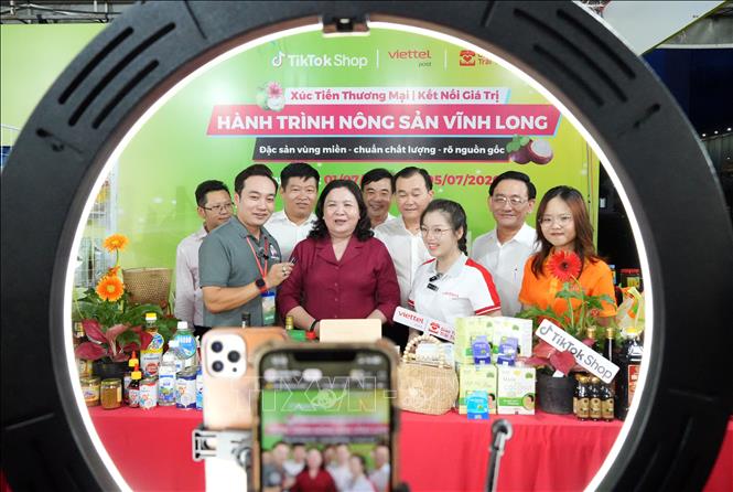 Phó Bí thư Thường trực Tỉnh ủy Vĩnh Long Hồ Thị Hoàng Yến (áo đỏ) và lãnh đạo tỉnh Vĩnh Long cùng tham gia phiên Megalive - livestream bán hàng trên nền tảng số tại lễ khai mạc. Ảnh: Phạm Minh Tuấn-TTXVN