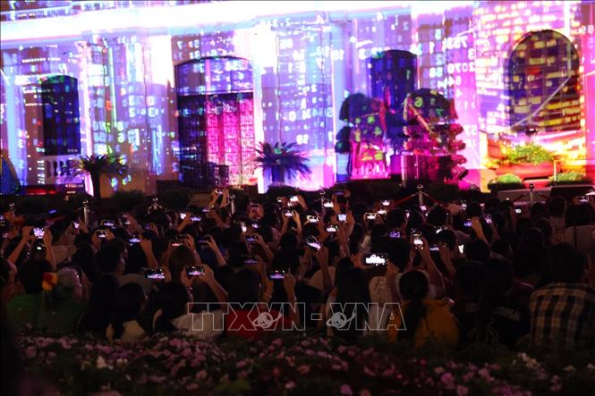 Người dân lưu lại những hình ảnh ấn tượng từ màn trình chiếu 3D mapping. Ảnh: Hồng Đạt - TTXVN