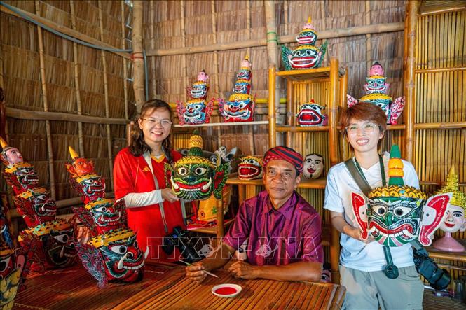 Du khách tìm hiểu nghệ thuật chế tác mặt nạ múa chằn của đồng bào Khmer. Ảnh: Khánh Hoà – TTXVN 