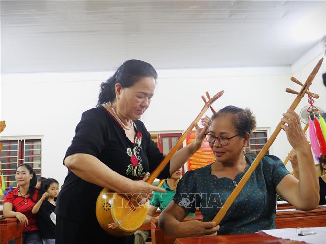 Nghệ sĩ ưu tú Hoàng Kim Tuế hướng dẫn học viên hát Then, đàn tính. Ảnh: Chu Hiệu - TTXVN