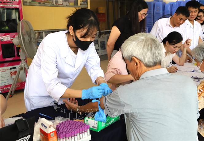 Thu nhận mẫu sinh phẩm ADN thân nhân liệt sĩ tại phường Cửa Nam (Hà Nội). Ảnh: Nguyễn Cúc - TTXVN